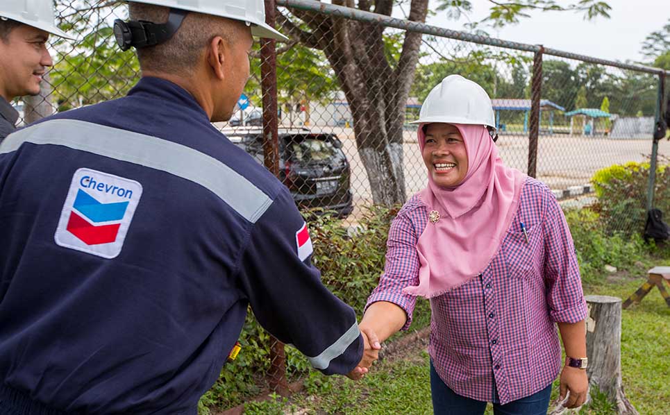 Chevron employee shaking hands with a local business development beneficiary