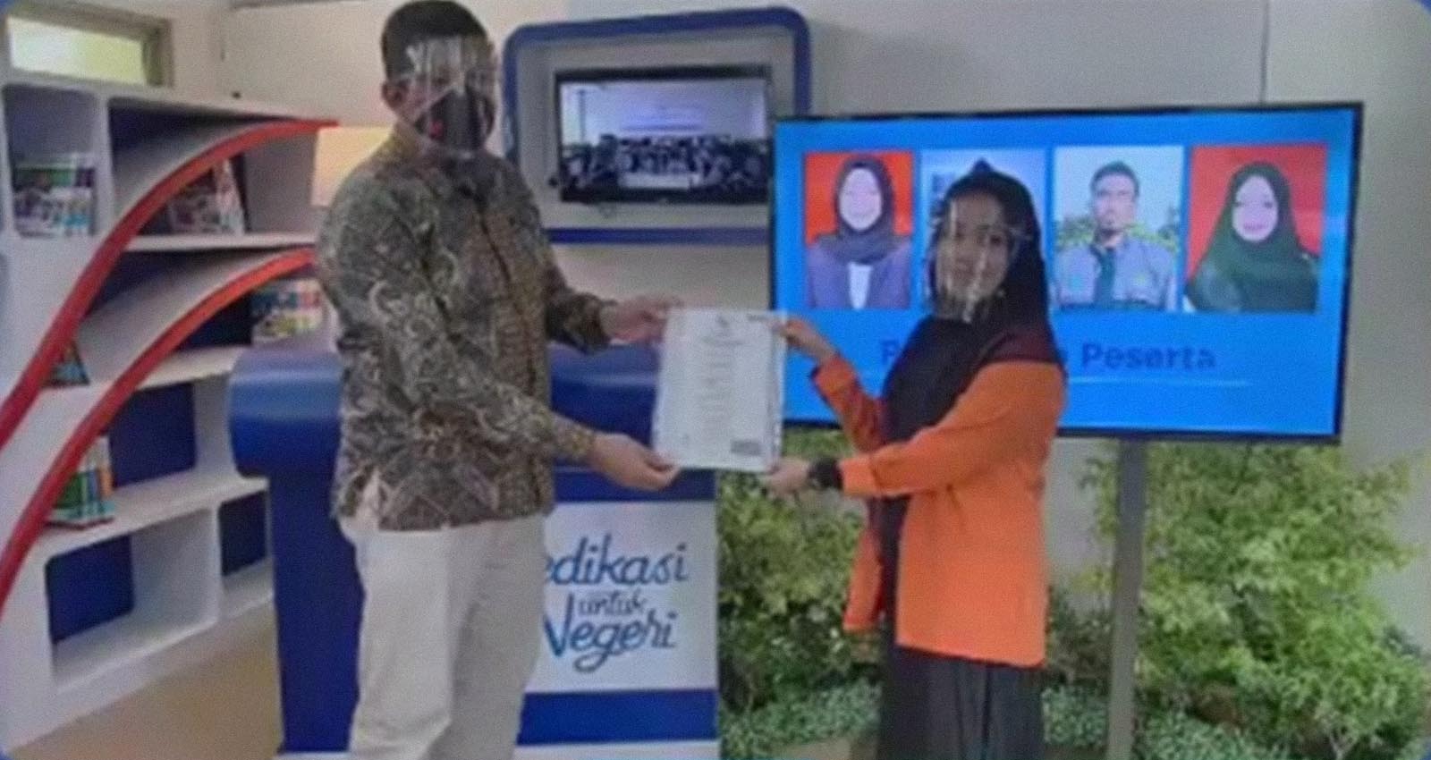 Graduate: Director of Politeknik Caltex Riau Dr. Mohammad Yanuar Hariyawan (left) presents a certificate to a Zahir Accounting training participant on Nov. 5.